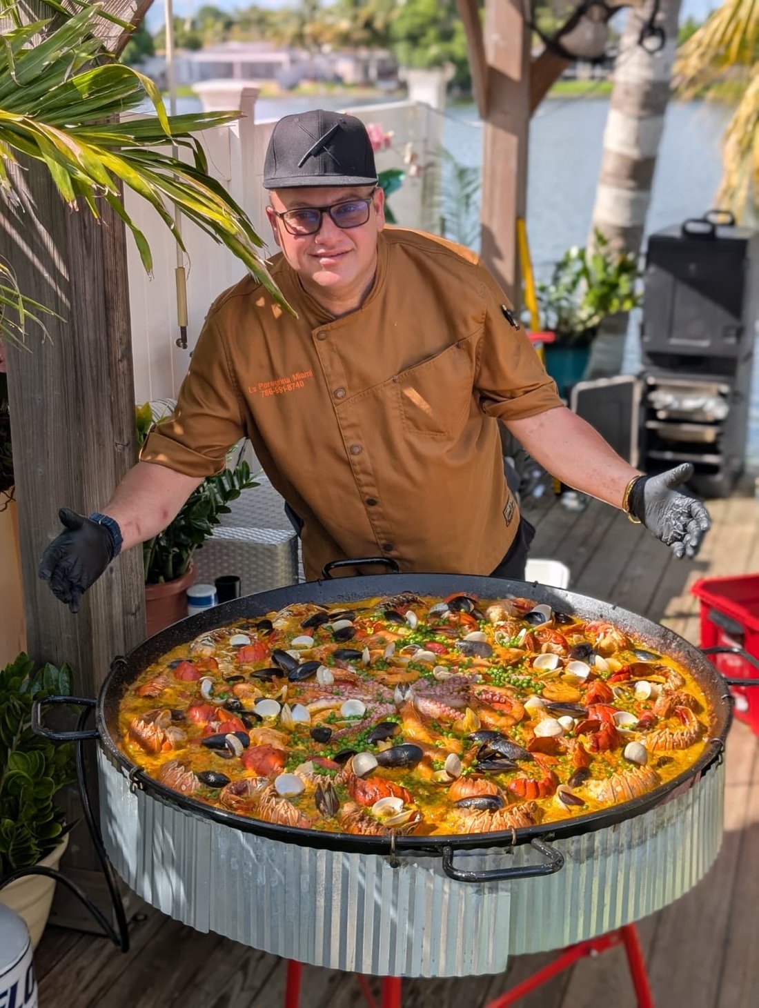Chef Reinaldo presenting a giant seafood paella at a Miami event